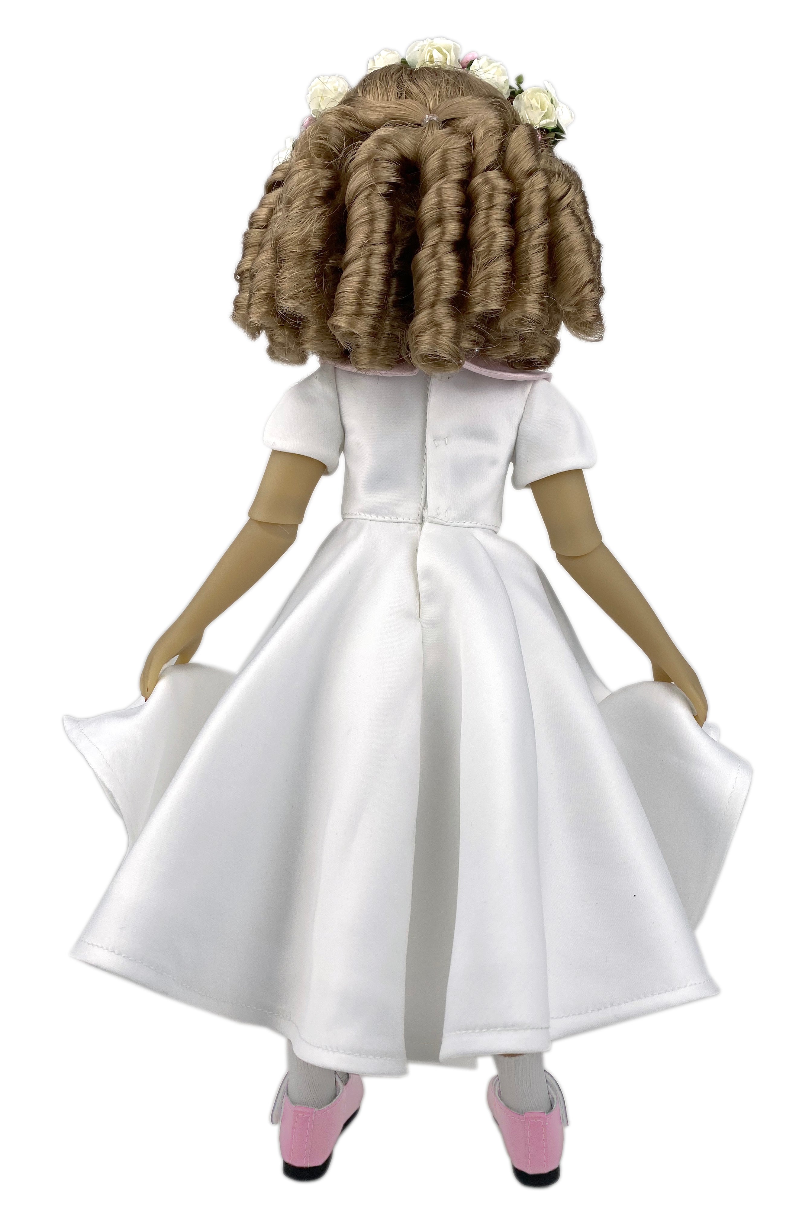 Doll wearing a white dress with a plain background