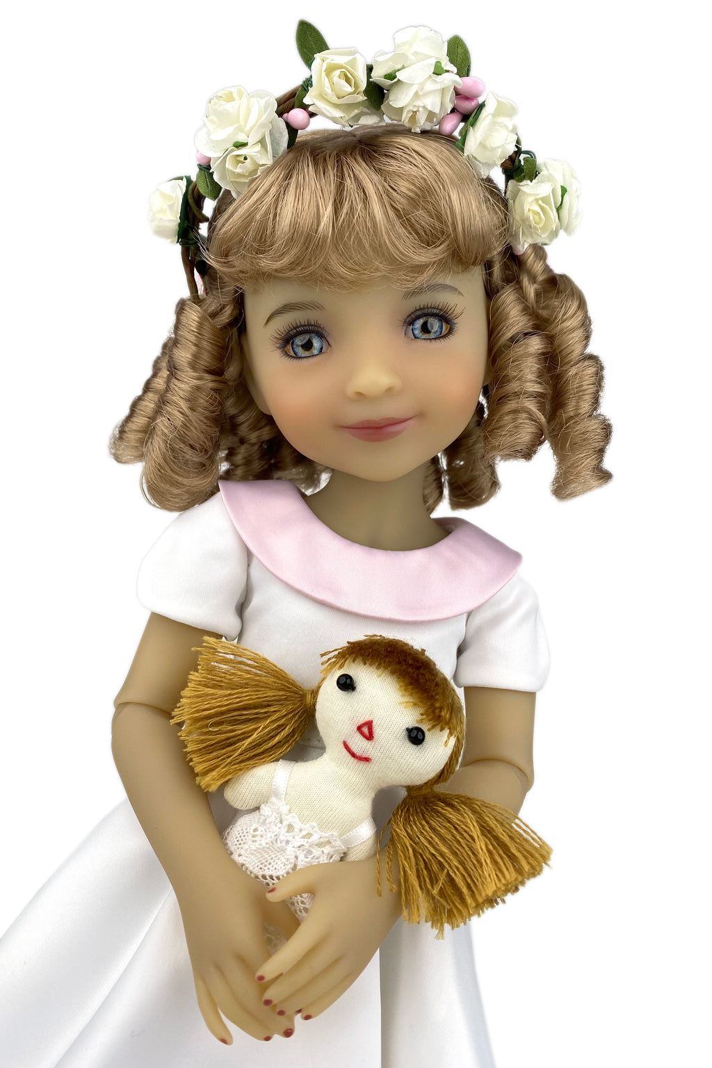 Doll with floral crown and white dress holding a small doll