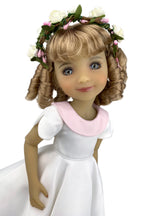 Doll in a white dress with a pink collar and floral headband on a white background