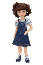 Doll wearing a denim dress with floral top on a white background