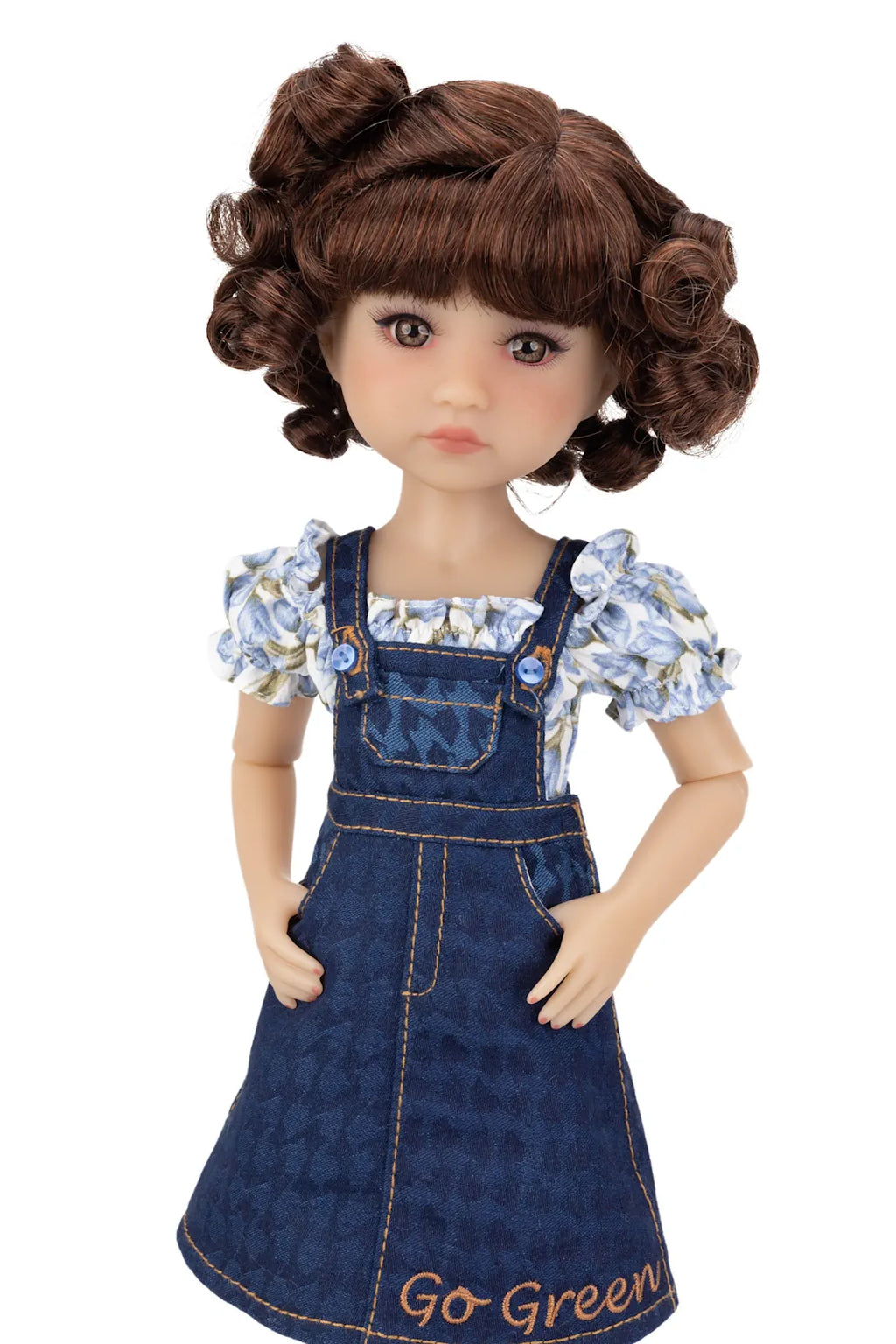 Doll wearing a denim dress with floral top on a white background