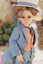 Doll in a formal outfit with a blue coat and hat, standing outdoors.