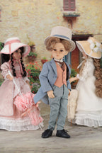 Three dolls in period costumes standing outdoors with a stone building in the background.