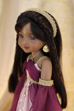 Doll with braided hair and traditional attire against a beige background
