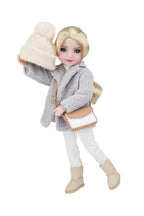 Doll wearing a gray coat, white pants, beige boots, and holding a cream hat and bag on a white background