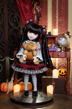 Doll in a Halloween-themed setting with pumpkins and decorations
