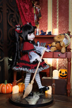 Doll in a Halloween-themed room with pumpkins and broomstick