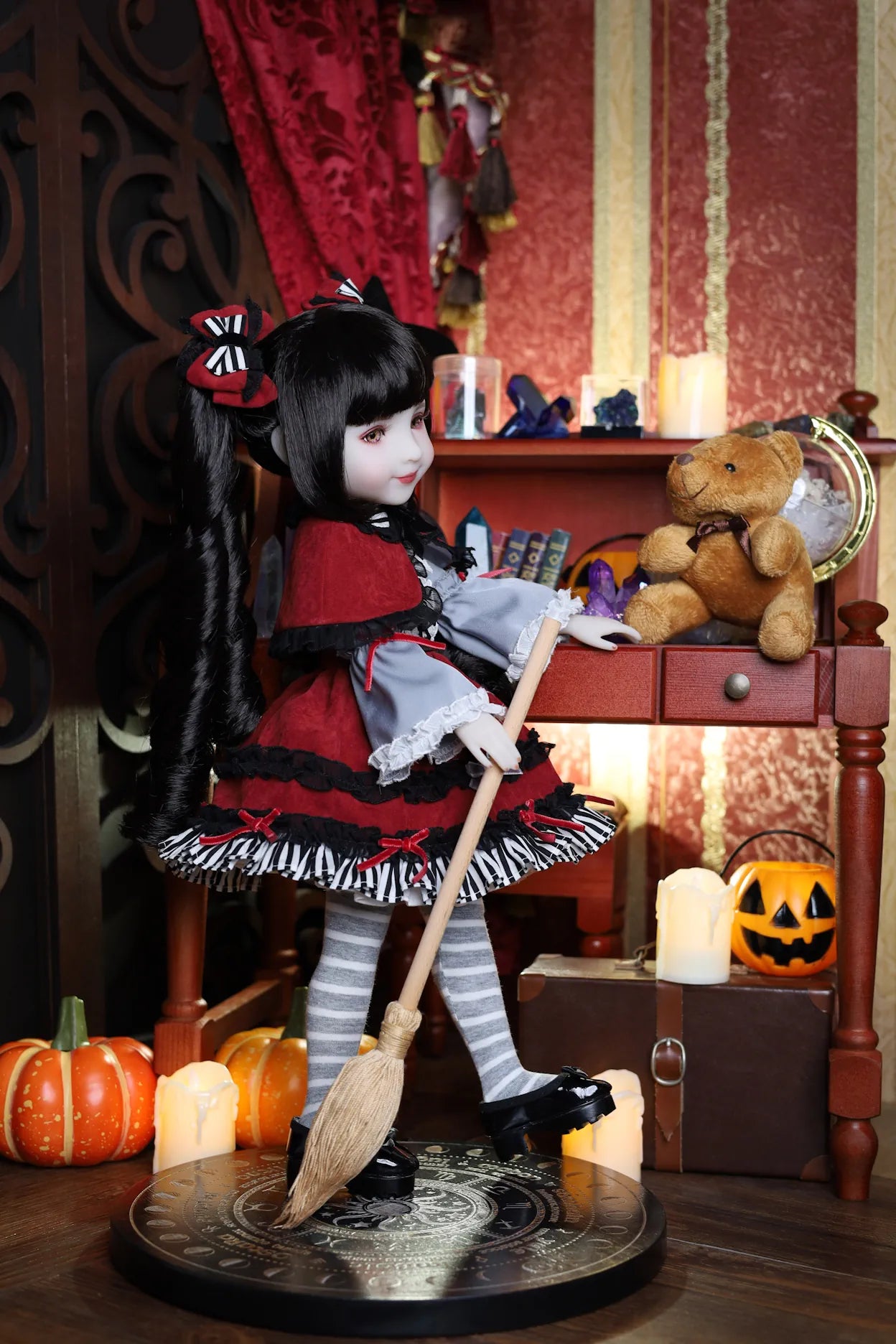 Doll in a Halloween-themed room with pumpkins and broomstick