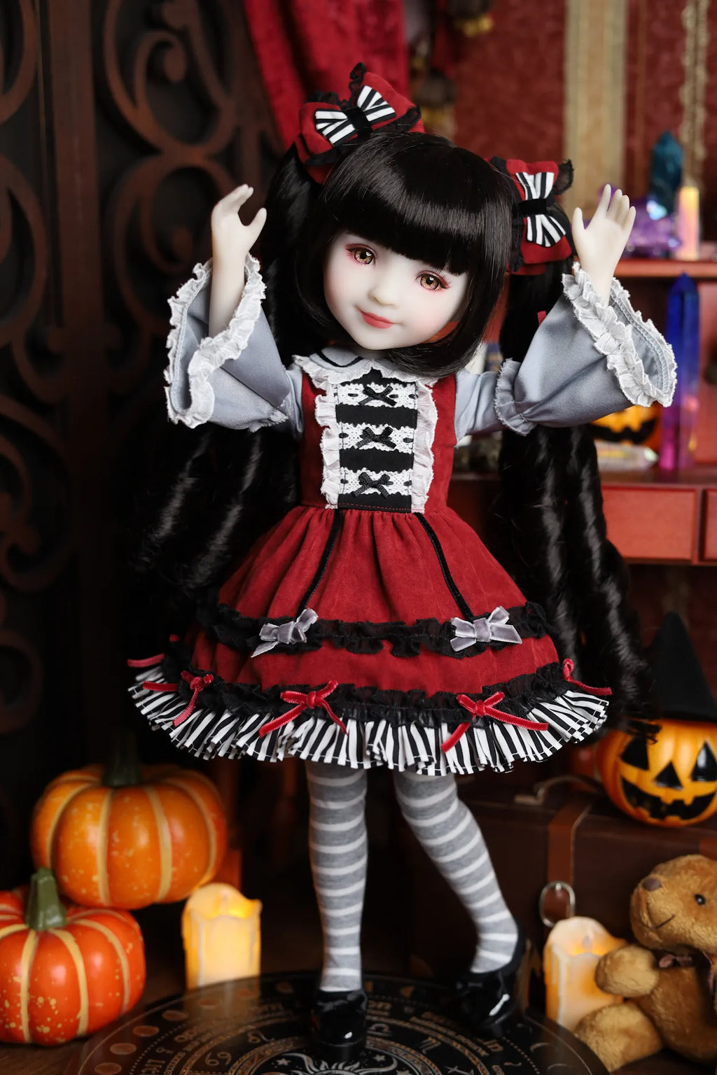 Doll in a red and black outfit with Halloween decorations in the background
