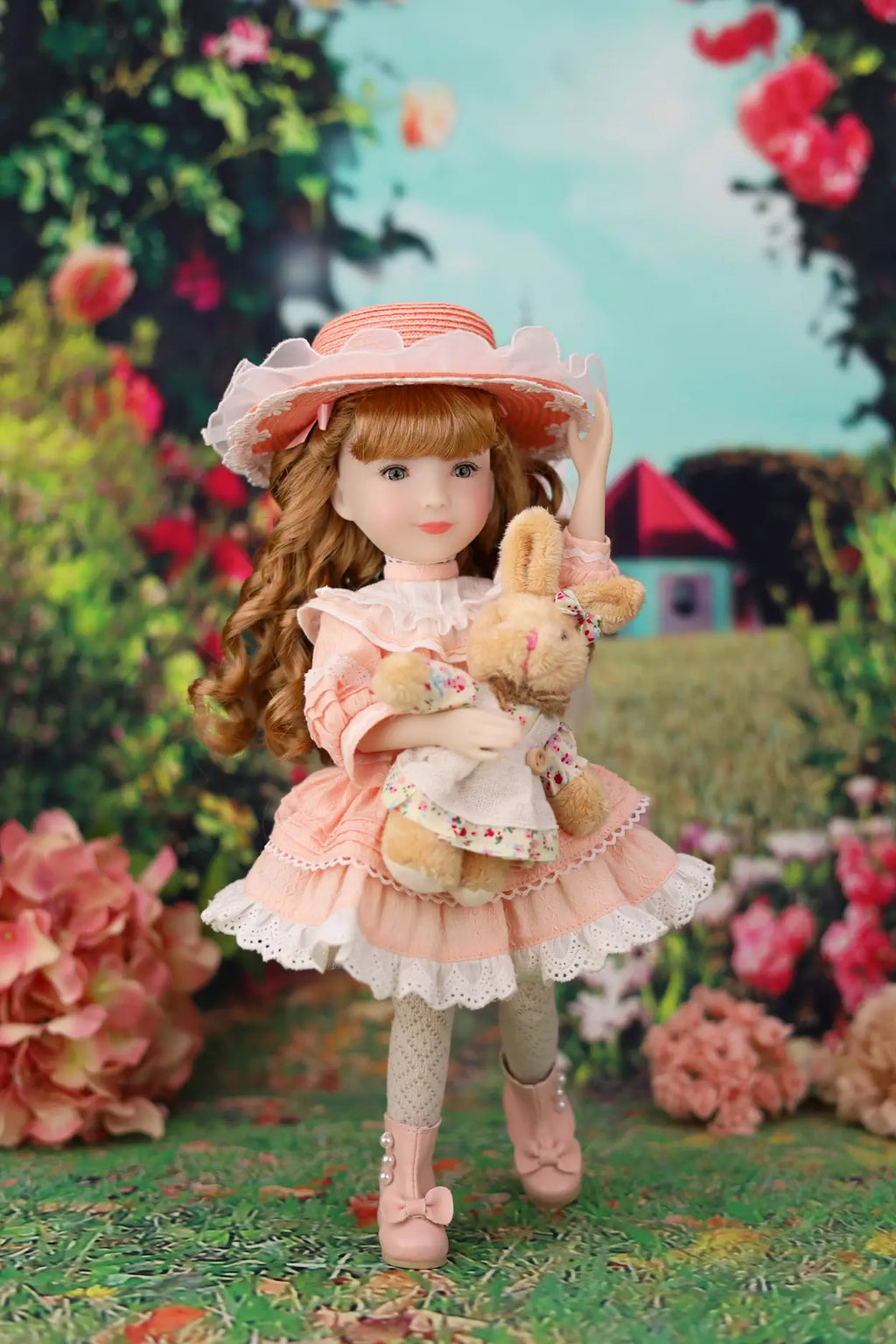 Doll in a pink dress and hat holding a  rabbit plush toy in a garden setting
