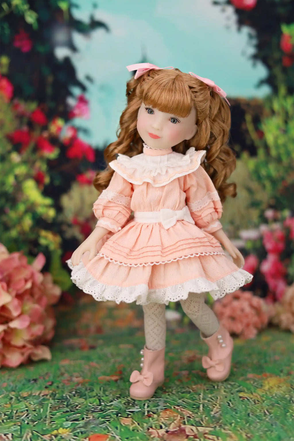 Doll in a pink dress standing outdoors with flowers and greenery in the background