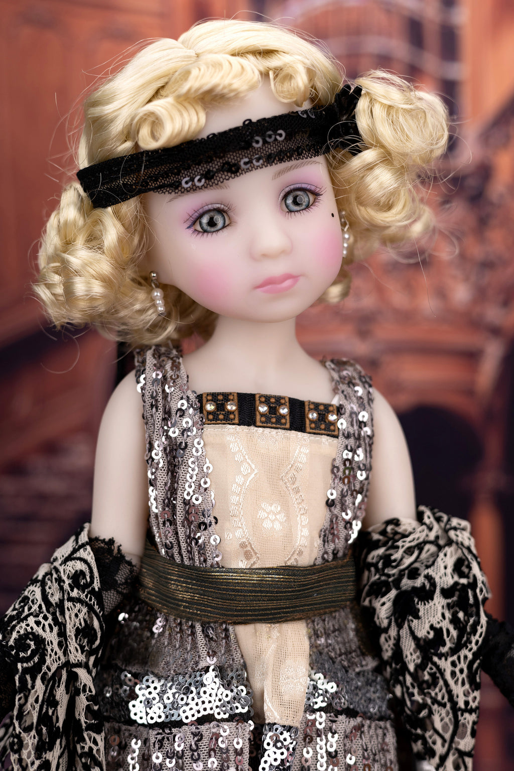 Doll with blonde hair and a decorative headband, wearing a sequined dress.