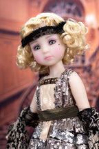 Doll with blonde hair and a sequined dress in front of a blurred background