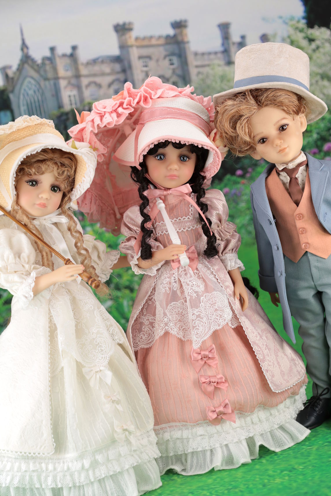 Three dolls in vintage clothing with a castle in the background