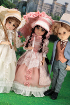 Three dolls in period costumes standing outdoors with a building in the background