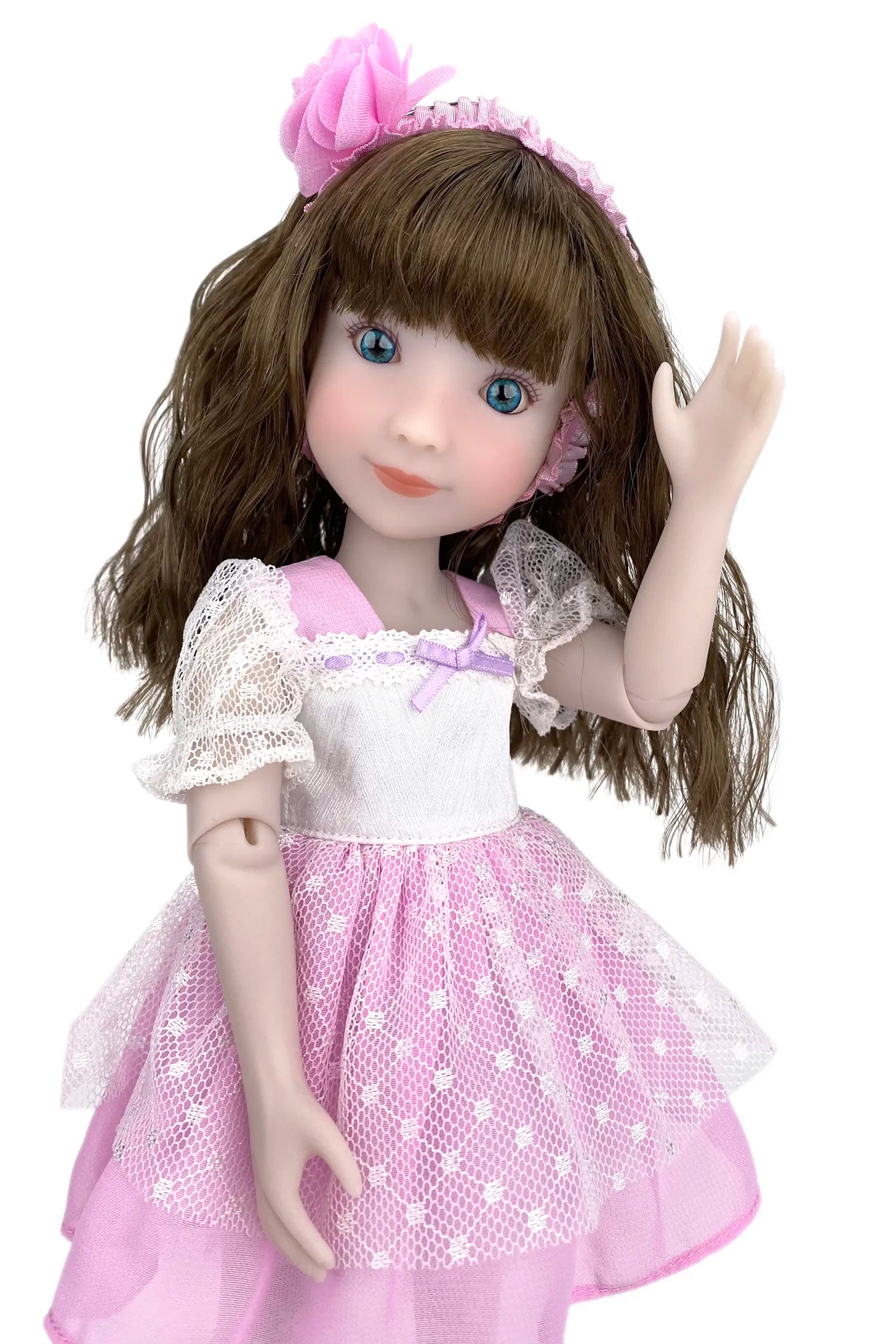 Doll with brown hair and a pink dress on a white background