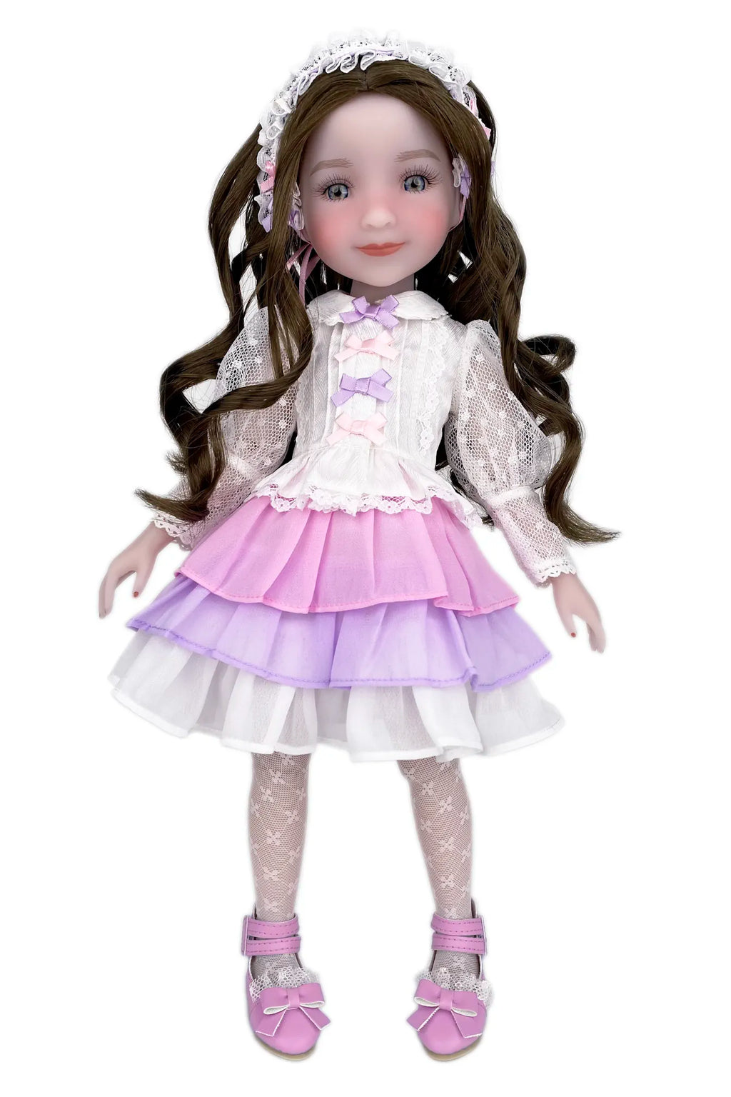 Doll with long brown hair wearing a white and purple outfit on a white background