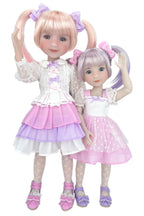 Two dolls with blonde hair styled in pigtails, wearing matching outfits with pink and purple accents.