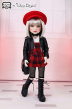 Doll wearing a red beret, black jacket, plaid skirt, and black boots on a white background.