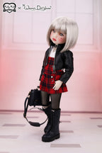 Doll wearing a black jacket, red plaid skirt, and black boots with a handbag on a white background.
