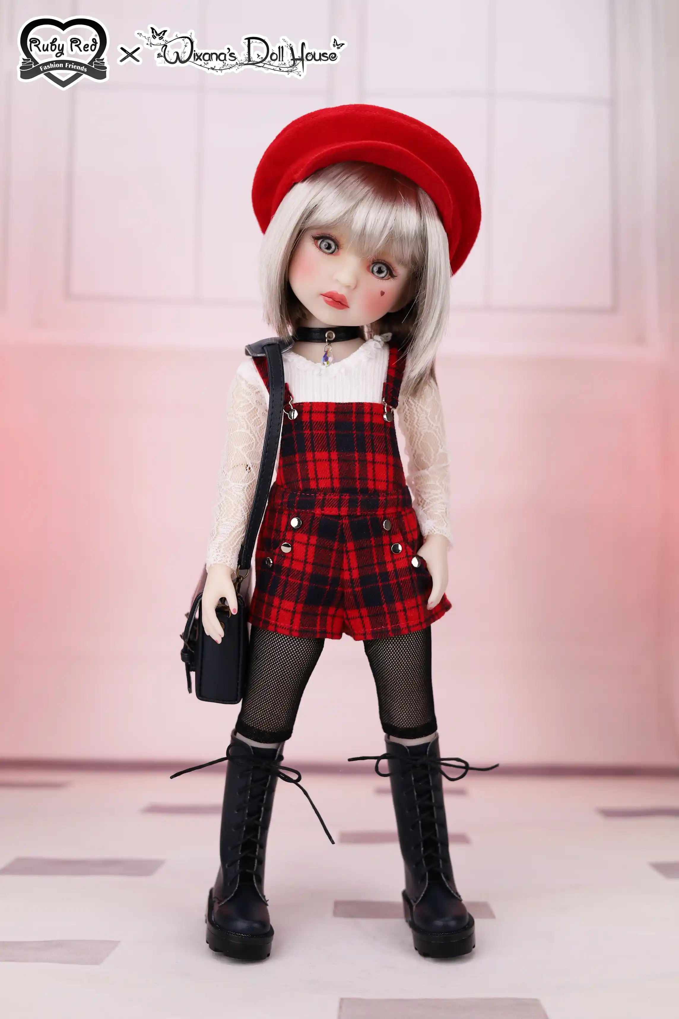 Doll wearing a red beret, plaid dress, and black boots with a blurred background