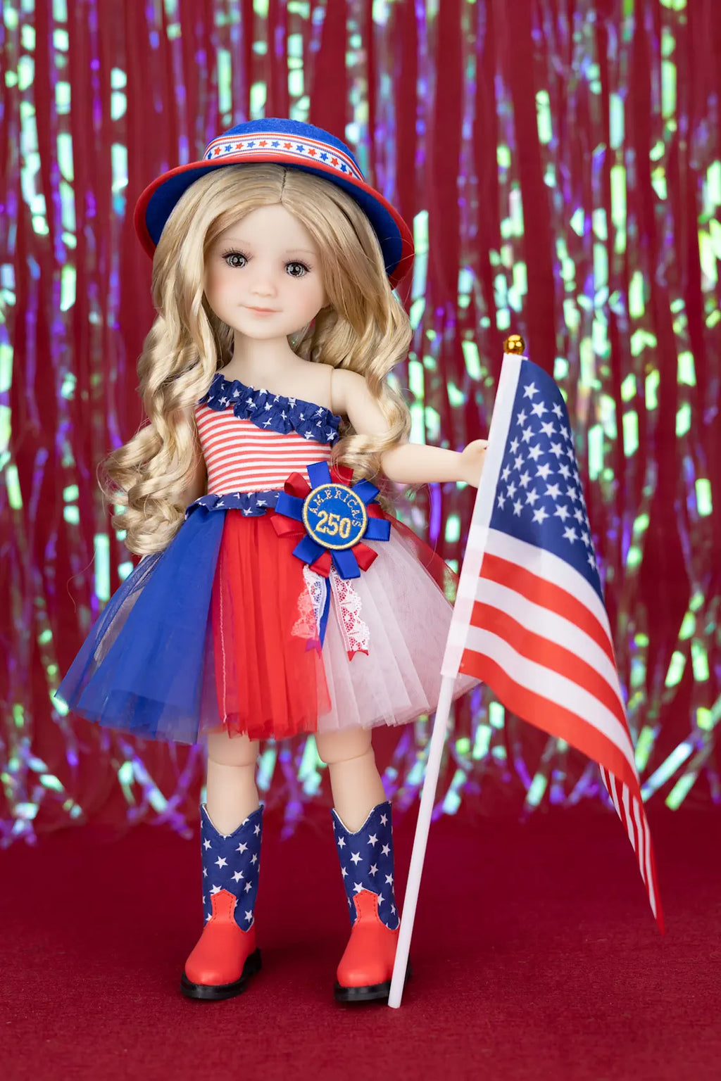 Doll in patriotic outfit with American flag and hat against a red and blue glittery background