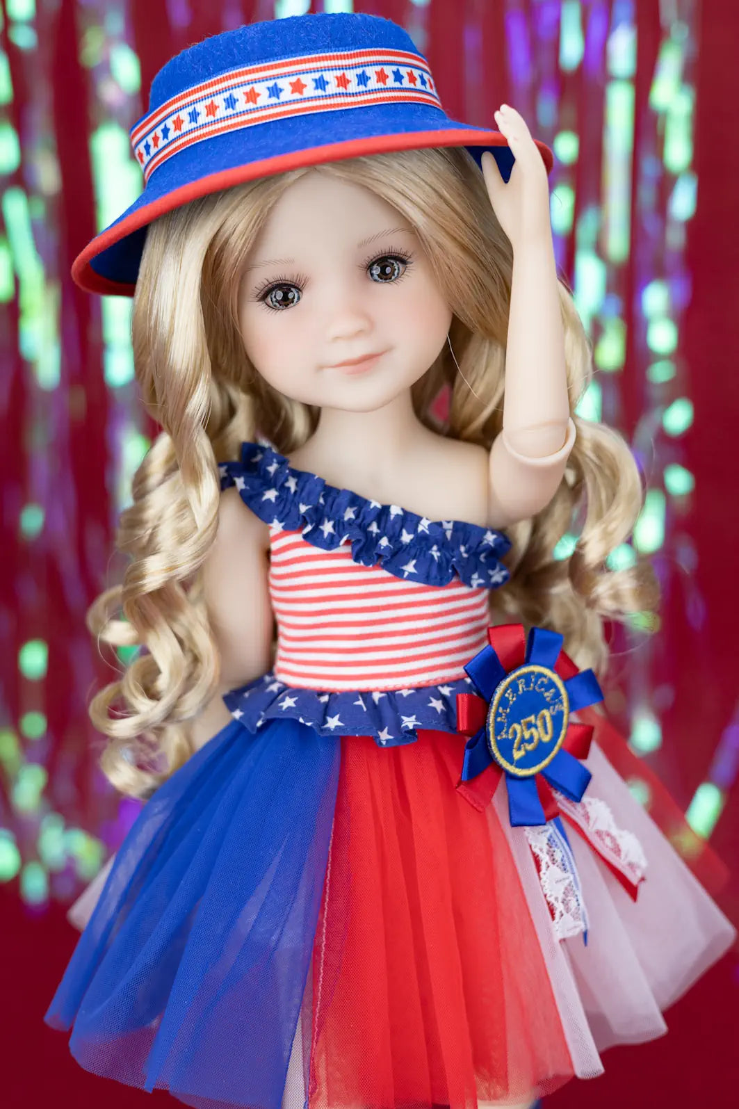 Doll wearing a patriotic outfit with a blue hat and dress against a red background