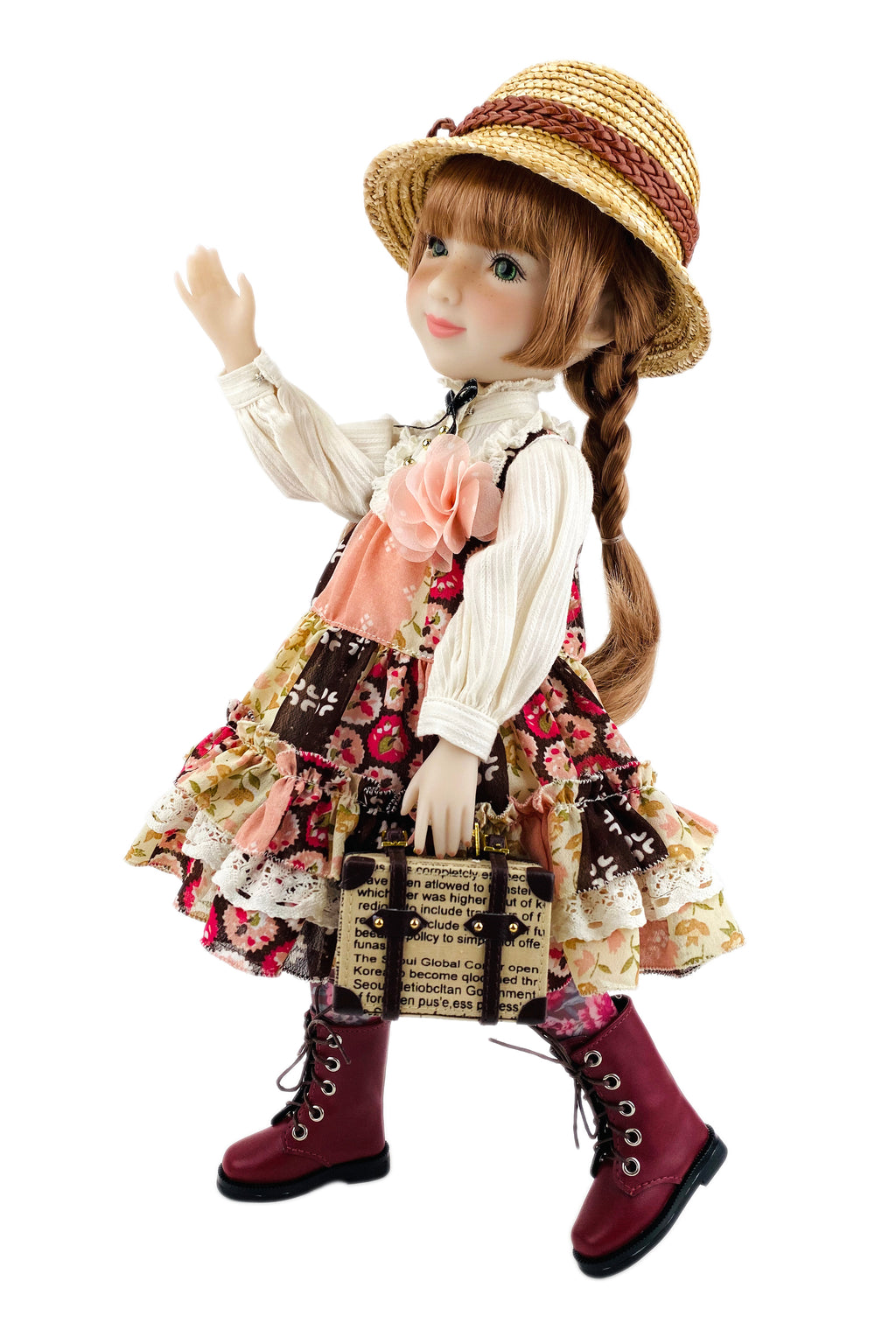 Doll in vintage outfit with hat, dress, and boots on a white background