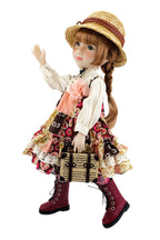 Doll in vintage outfit with hat, dress, and boots on a white background