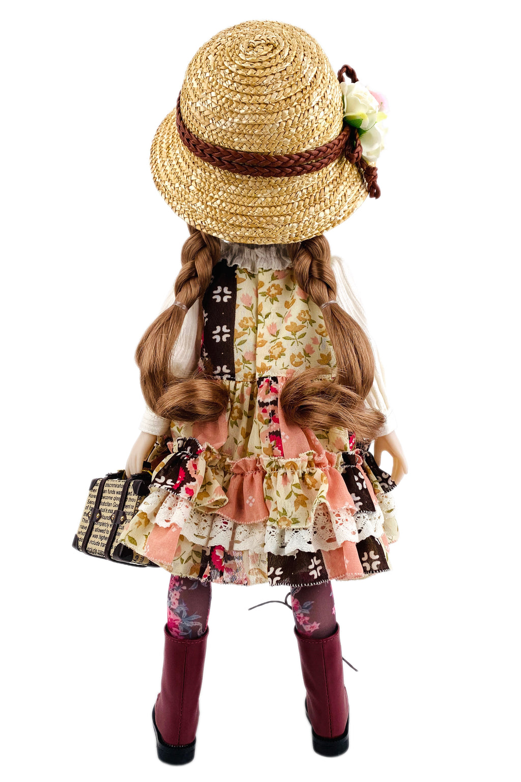 Doll with a floral dress, straw hat, and maroon boots on a white background