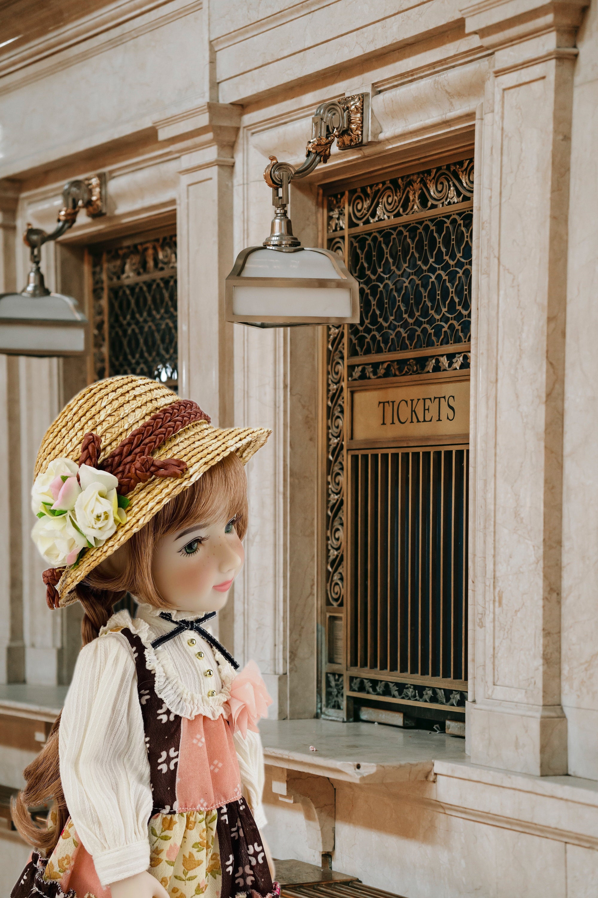 Vintage-style ticket booth with a doll wearing a straw hat and floral dress.