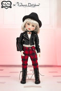 Doll wearing a black leather jacket, red plaid pants, and black hat on a pink background