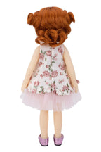 Doll with red hair styled in pigtails wearing a floral dress on a white background