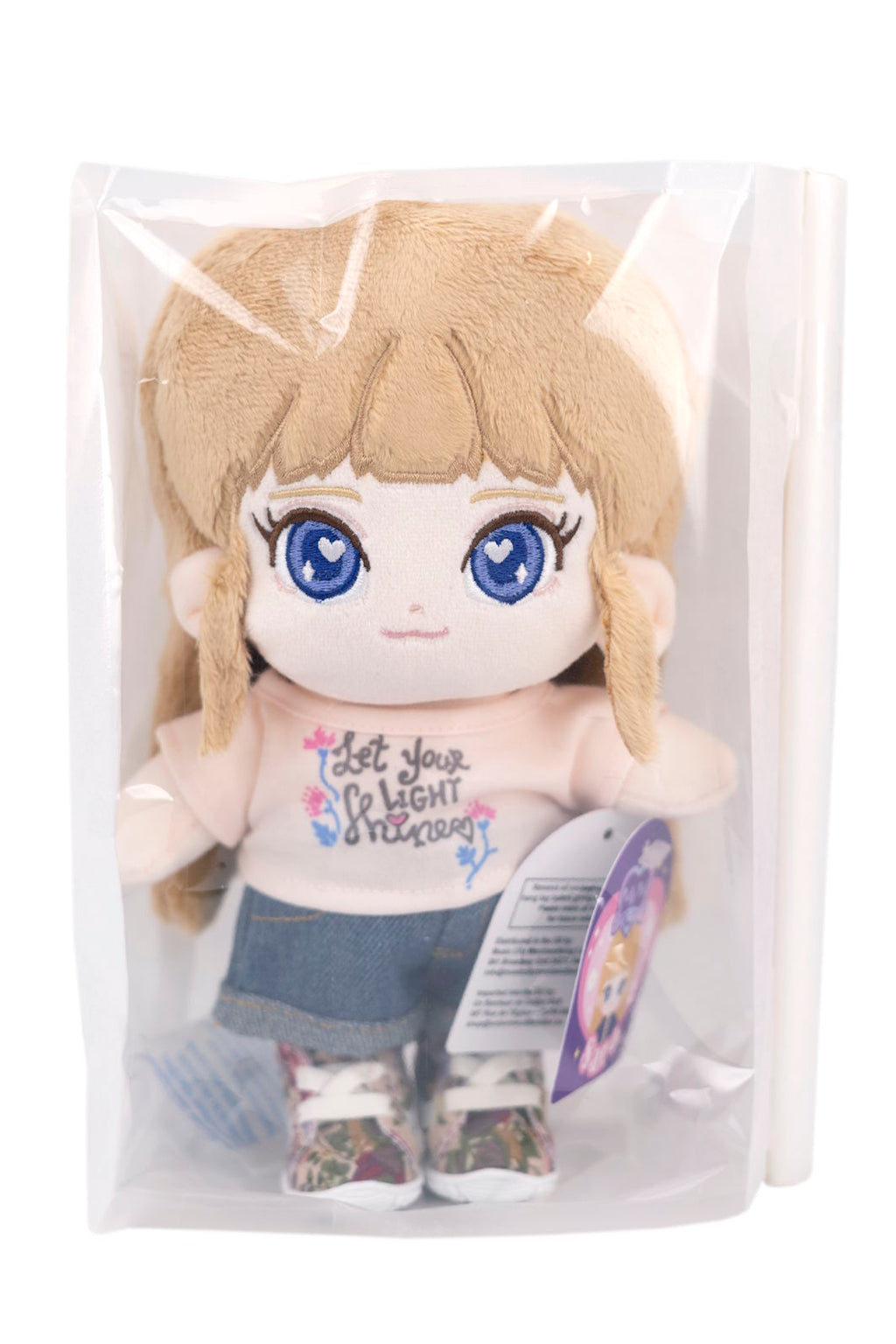 Fluffy Sara plush toy with blue eyes and blonde hair in a clear package