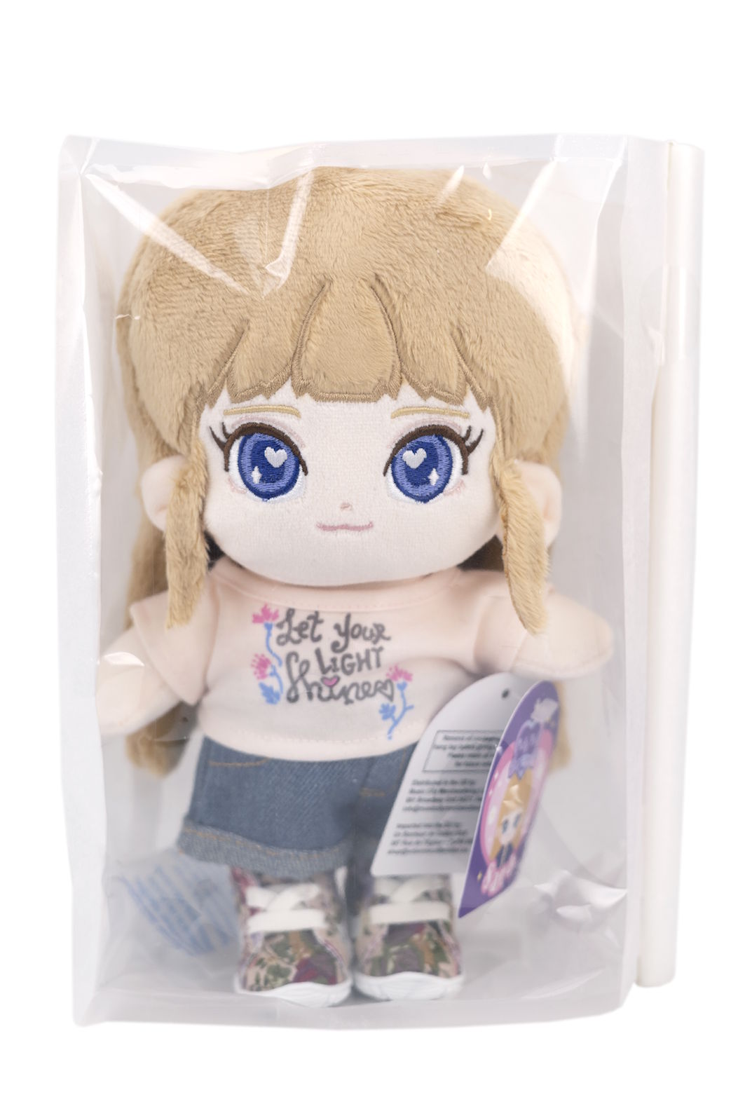 Fluffy Sara plush toy with blue eyes and blonde hair in a clear package