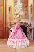 Doll in a pink historical dress with a decorative hairstyle in an ornate room.