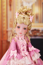 Doll with blonde hair and pink outfit in a decorative setting