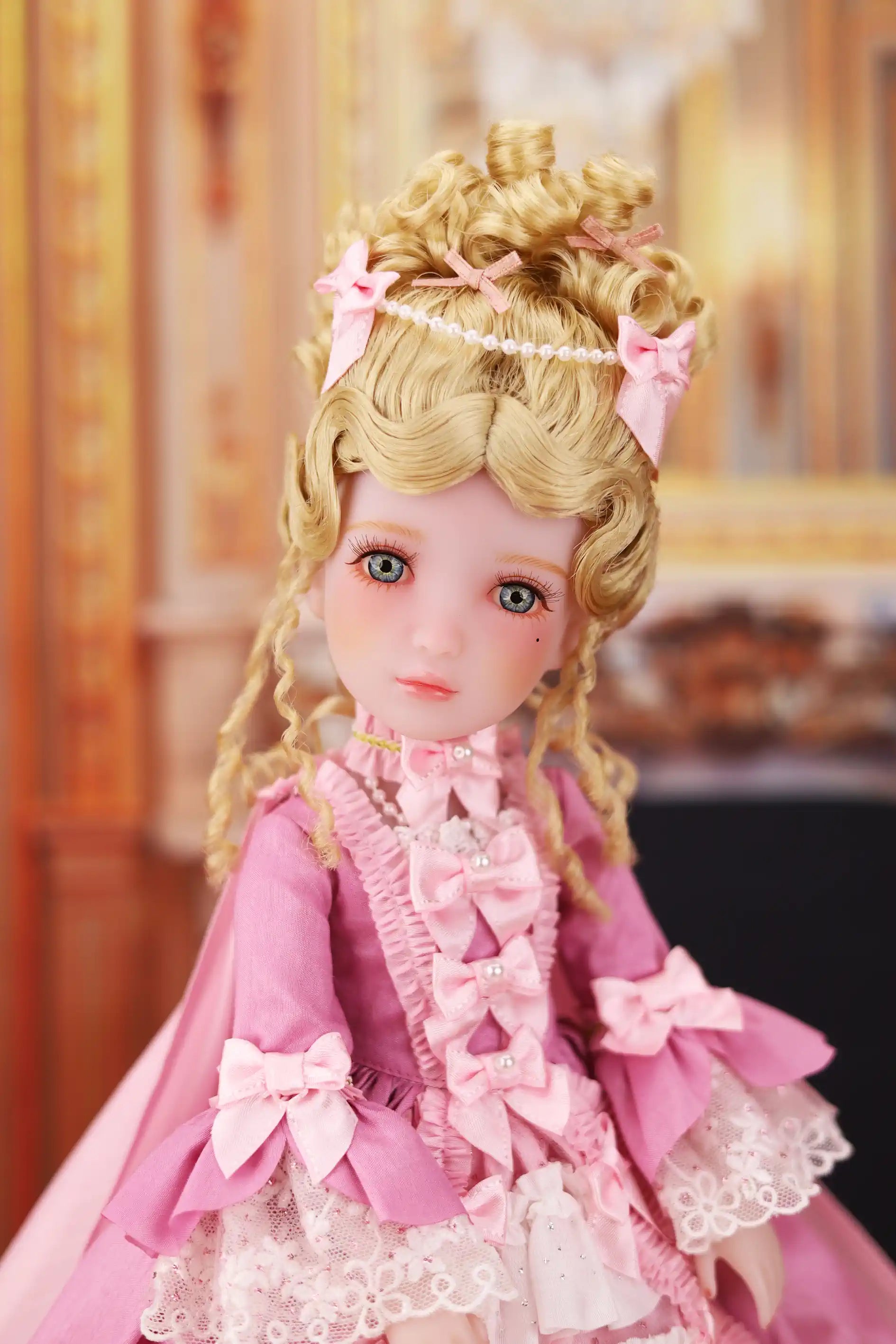 Doll with blonde hair and pink outfit in a decorative setting