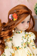 Doll with red hair and floral headband wearing a floral dress.