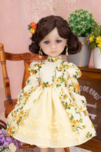 Doll in a yellow floral dress with a decorative headpiece against a pink wall.