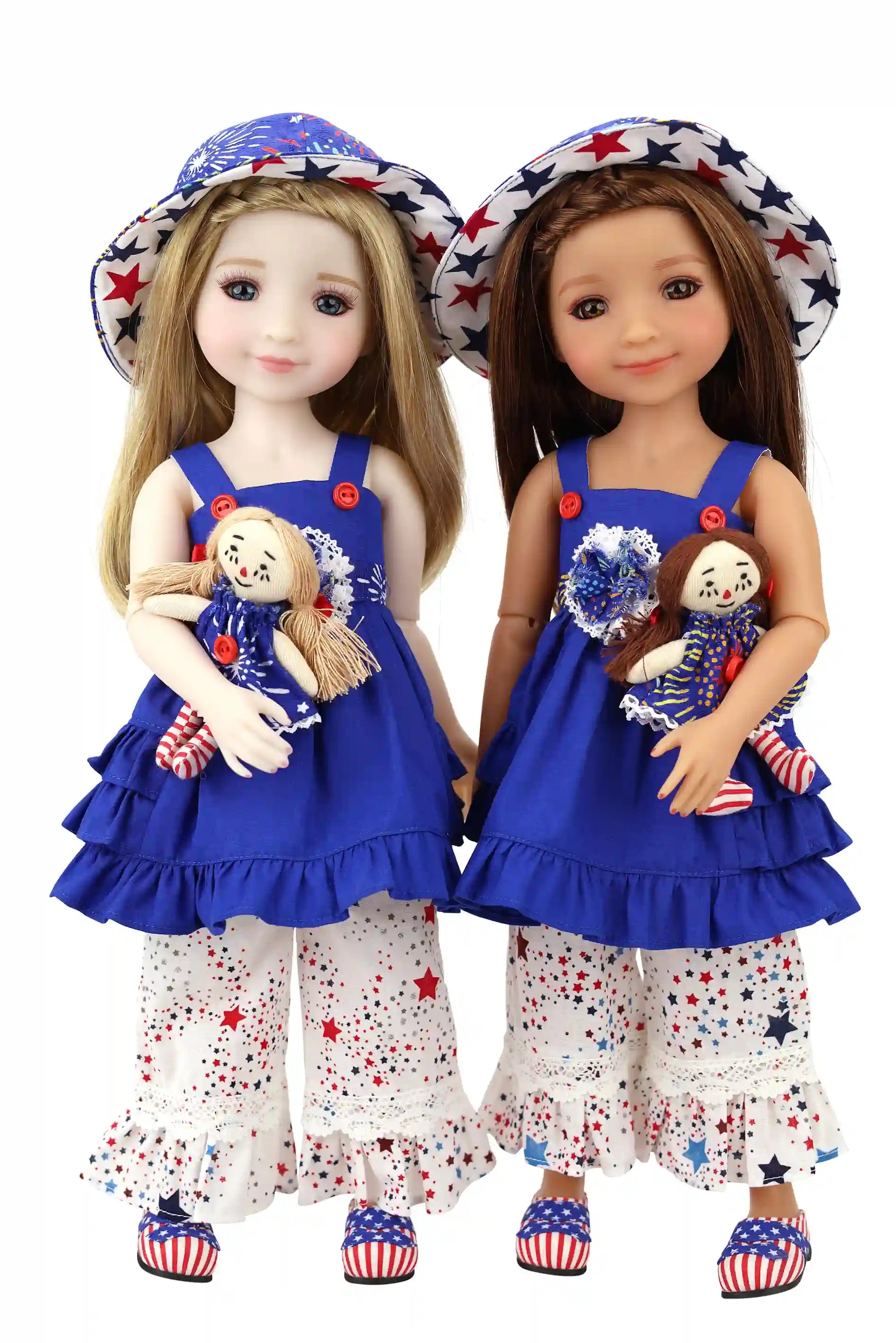 Two dolls wearing matching outfits with blue dresses and white pants, holding small dolls.