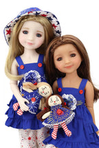 Two dolls in matching blue outfits with red buttons, holding small dolls, on a white background.