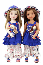 Two dolls wearing matching outfits with blue dresses and white pants, holding small dolls.