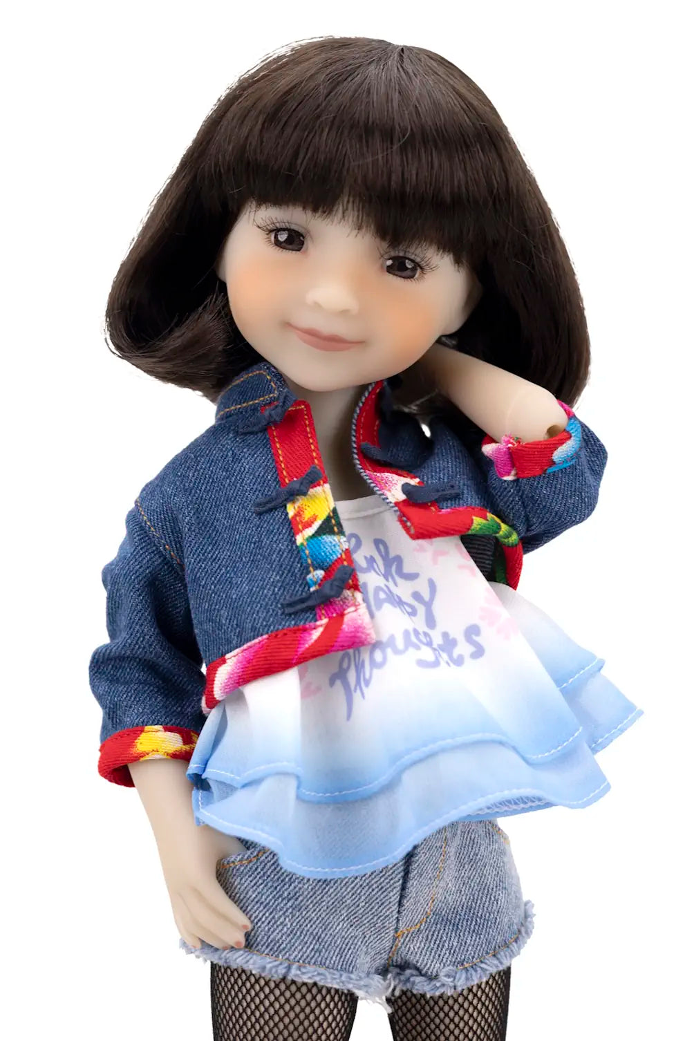Doll wearing a denim jacket with colorful accents and a white shirt with text on a white background