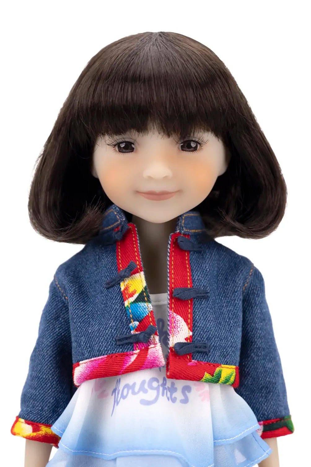 Doll wearing a colorful jacket on a white background
