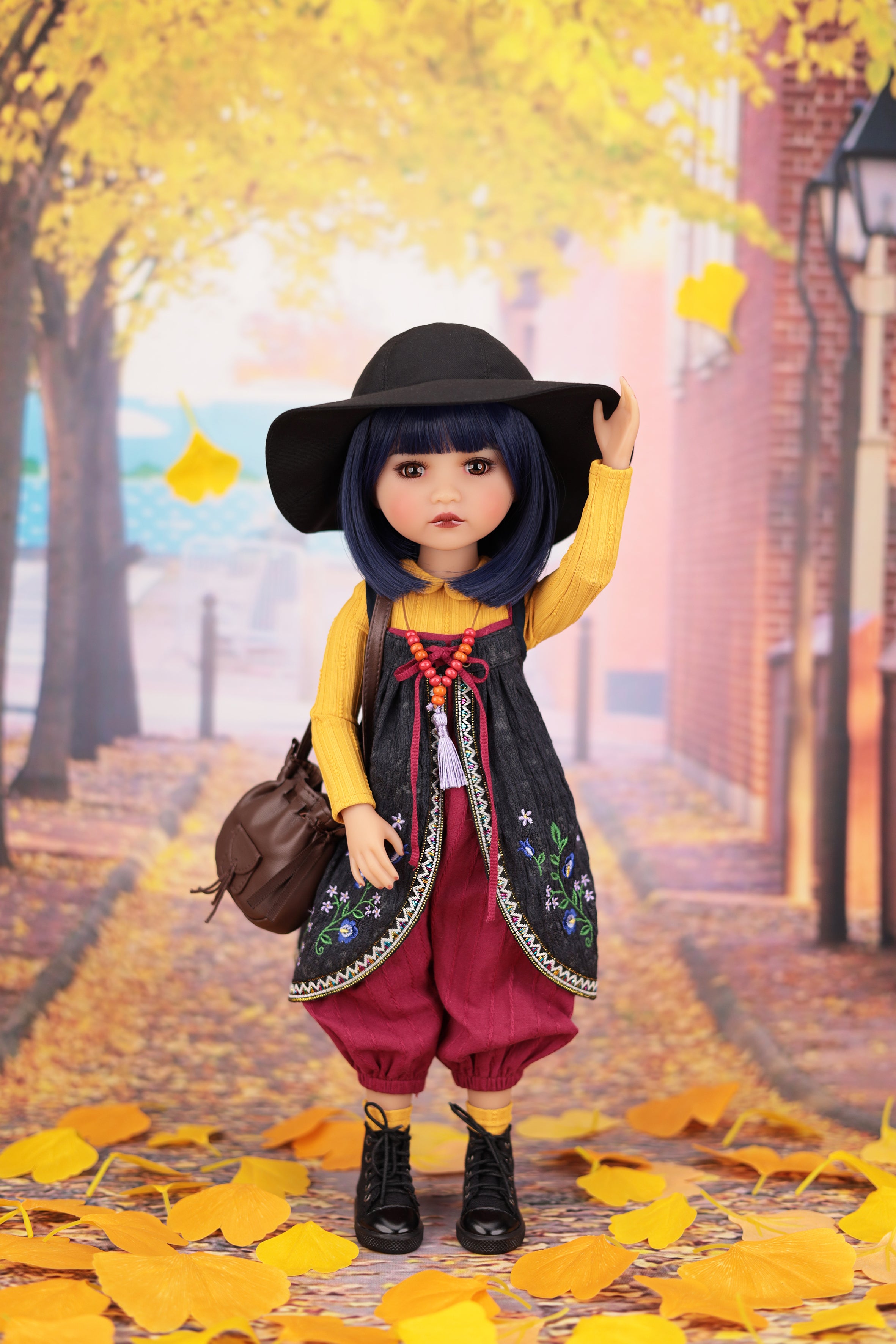 Doll in autumn setting with yellow leaves and brick building