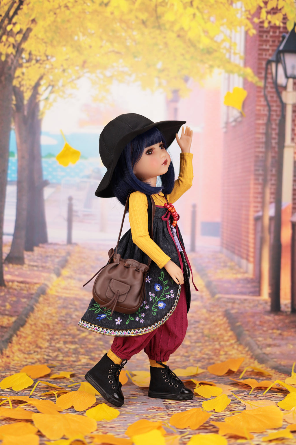 Doll in autumn setting with yellow leaves and brick building