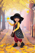 Doll in autumn setting with yellow leaves and brick building