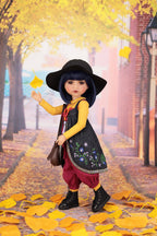 Doll in autumn setting with yellow leaves and brick building