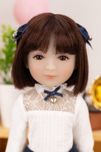 Doll with brown hair and a white outfit with lace details, wearing blue ribbons.